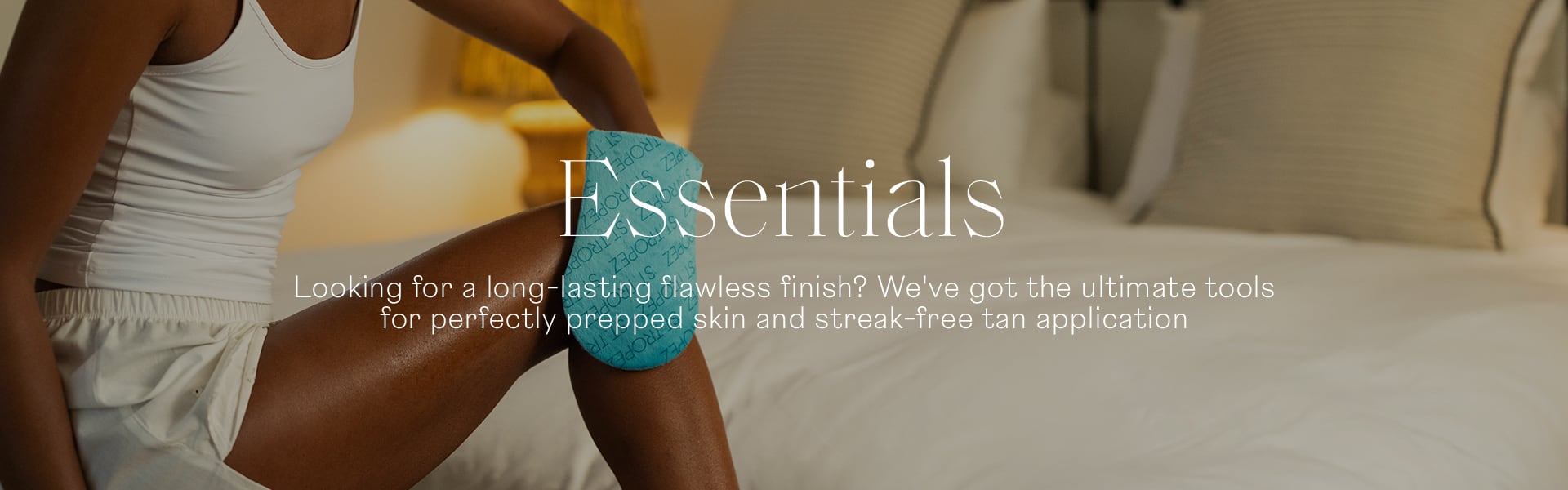 Essentials woman using tanning mit to apply tan to legs